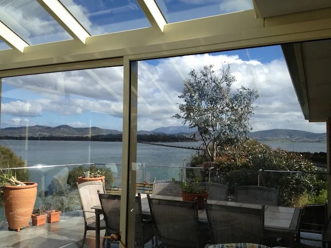Streak-free sunroom windows cleaned by Professional Window Cleaners, overlooking the water